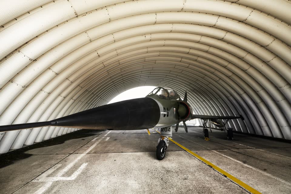 Fighter aircraft inside an arched hangar